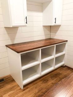 an empty room with white cabinets and wood flooring