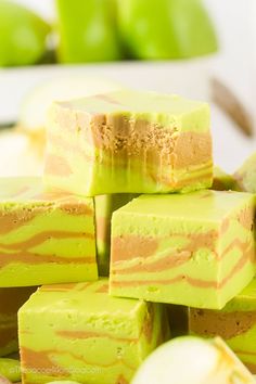 several pieces of cake sitting on top of each other in front of some green apples