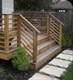 a wooden deck with planters on it and steps leading up to the front door