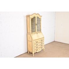 an old dresser with a mirror on the top and drawers below, in front of a white brick wall