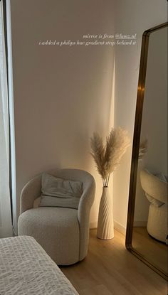 a white chair sitting next to a large mirror