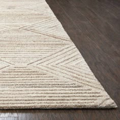 a beige rug on top of a wooden floor