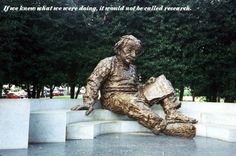 a statue of a man sitting on top of a cement slab in front of trees