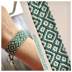 a woman's arm wearing a green and white beaded bracelet with tassels