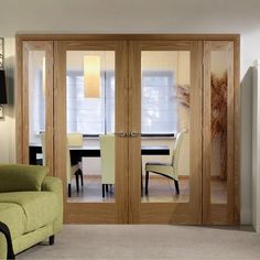 a living room filled with furniture next to a dining room table and two doors that open