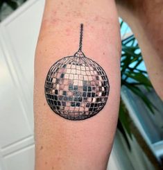 a black and white photo of a disco ball tattoo