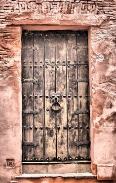 an old door with iron bars on the side of a stone building in arizona, usa