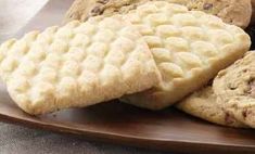 several cookies are stacked on a wooden plate