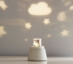 a white table with a light on top of it and stars projected over the wall