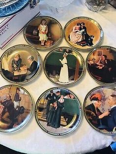 six plates with pictures of people on them sitting on a table next to a box