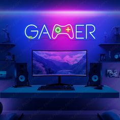 a computer monitor sitting on top of a desk in front of a neon sign that reads gamer