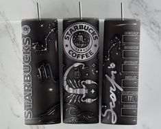 three starbucks coffee mugs are lined up on a marble countertop with zodiac symbols