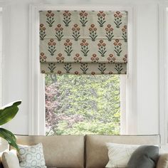 a living room with a couch and window coverings