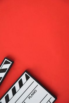 a close up of a movie clapper on a red background with space for text