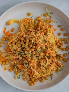 a white plate topped with lots of food on top of a table next to utensils