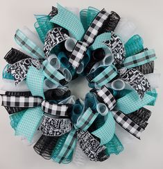 a black and white checkerboard wreath with blue ribbons on it, sitting on a table