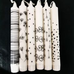 four candles with designs on them sitting next to each other