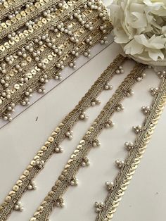 Enhance your bridal wear and DIY projects with our Pearl Beaded Lace with Metallic Sequin Trim. This elegant tassel pearl lace border is perfect for adding a luxurious touch to bridal dresses, costumes, hat making, and home decor. The intricate design features delicate pearls and shimmering sequins, offering a sophisticated finish to any outfit or accessory. . Elevate your creations with this beautiful pearl edging lace--order today for a timeless, elegant look! 𝐏𝐞𝐚𝐫𝐥 𝐁𝐞𝐚𝐝𝐞𝐝 𝐋𝐚𝐜𝐞 Beads Lace Border, Pearl Lace Border, Tassels Designs, Saree Tassels Designs, Tassel Lace, Saree Tassels, How To Make Decorations, Pearl Lace, Pearl And Lace