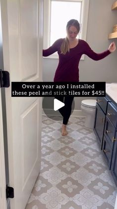 a woman is standing in the bathroom with her arms out and feet up on the floor