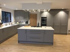 a kitchen with grey cabinets and white counter tops