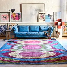 a living room filled with furniture and pictures on the wall above it's colorful rug