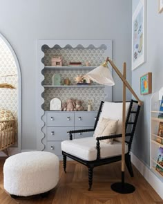 a baby's room with a chair, crib and bookshelf in the corner