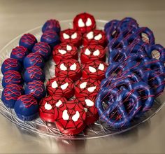 spiderman cookies and pretzels are arranged on a glass platter with red white and blue frosting