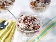 an ice cream sundae in a glass dish on a table with two spoons