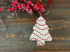 a christmas tree ornament hanging on a wooden table