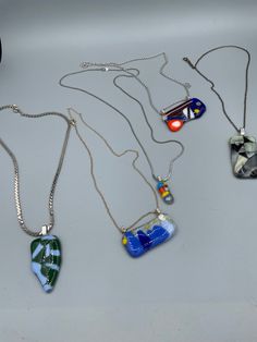 four necklaces with different designs on them