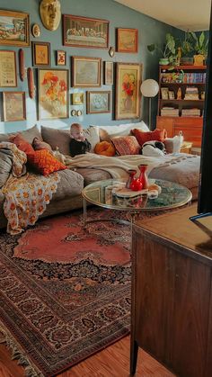 a living room filled with lots of furniture and pictures on the wall above it's coffee table