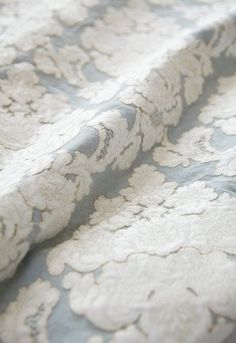 a close up view of a blue and white floral pattern on a bed sheet or comforter