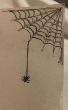 a drawing of a spider web hanging from the side of a piece of white paper