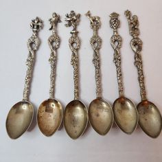 five silver spoons are lined up in a row