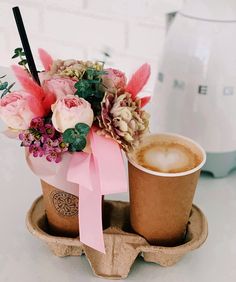 two coffee cups with flowers in them on a tray