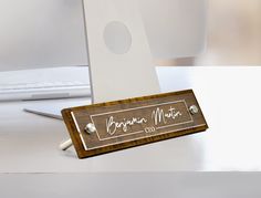 a wooden business card holder sitting on top of a desk