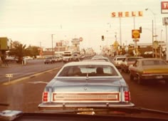 an old car is stopped at a stoplight in the middle of a busy street