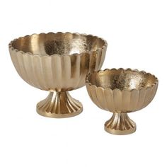 two gold colored bowls sitting on top of each other