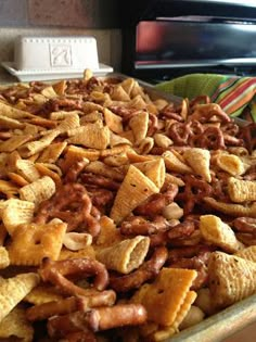 a large bowl filled with cheetos sitting on top of a counter next to a microwave