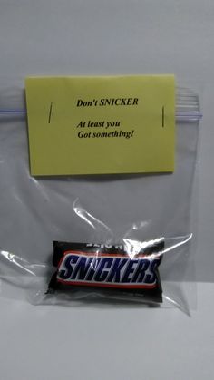 a bag of snickker candy sitting on top of a counter next to a note