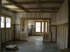 an empty room with wooden beams and windows