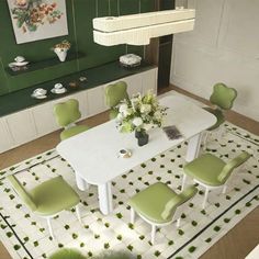 a dining room with green chairs and a white table surrounded by rugs on the floor