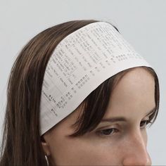 a close up of a person wearing a paper headband with writing on it's side