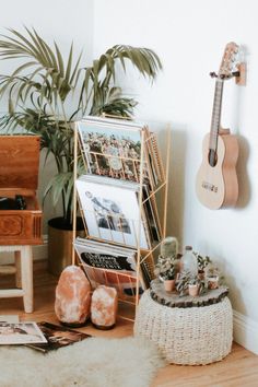 there is a guitar and other items on the floor next to a potted plant