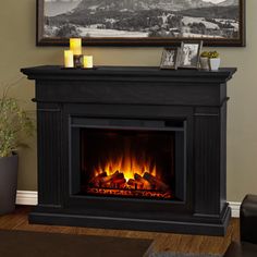 a living room with a fire place in the center and a painting on the wall