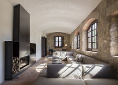 a living room filled with lots of furniture next to a wall mounted tv and fire place