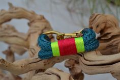 a red, green and yellow bracelet on a wooden branch