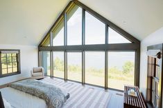 a bedroom with large windows and a bed