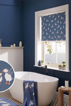 a bathroom with blue walls and white bathtub in the center is decorated with penguin wallpaper