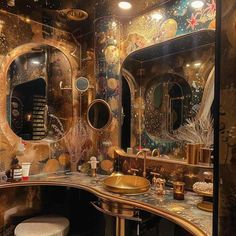 an elaborately decorated bathroom with gold fixtures and mirrors on the wall, along with two stools